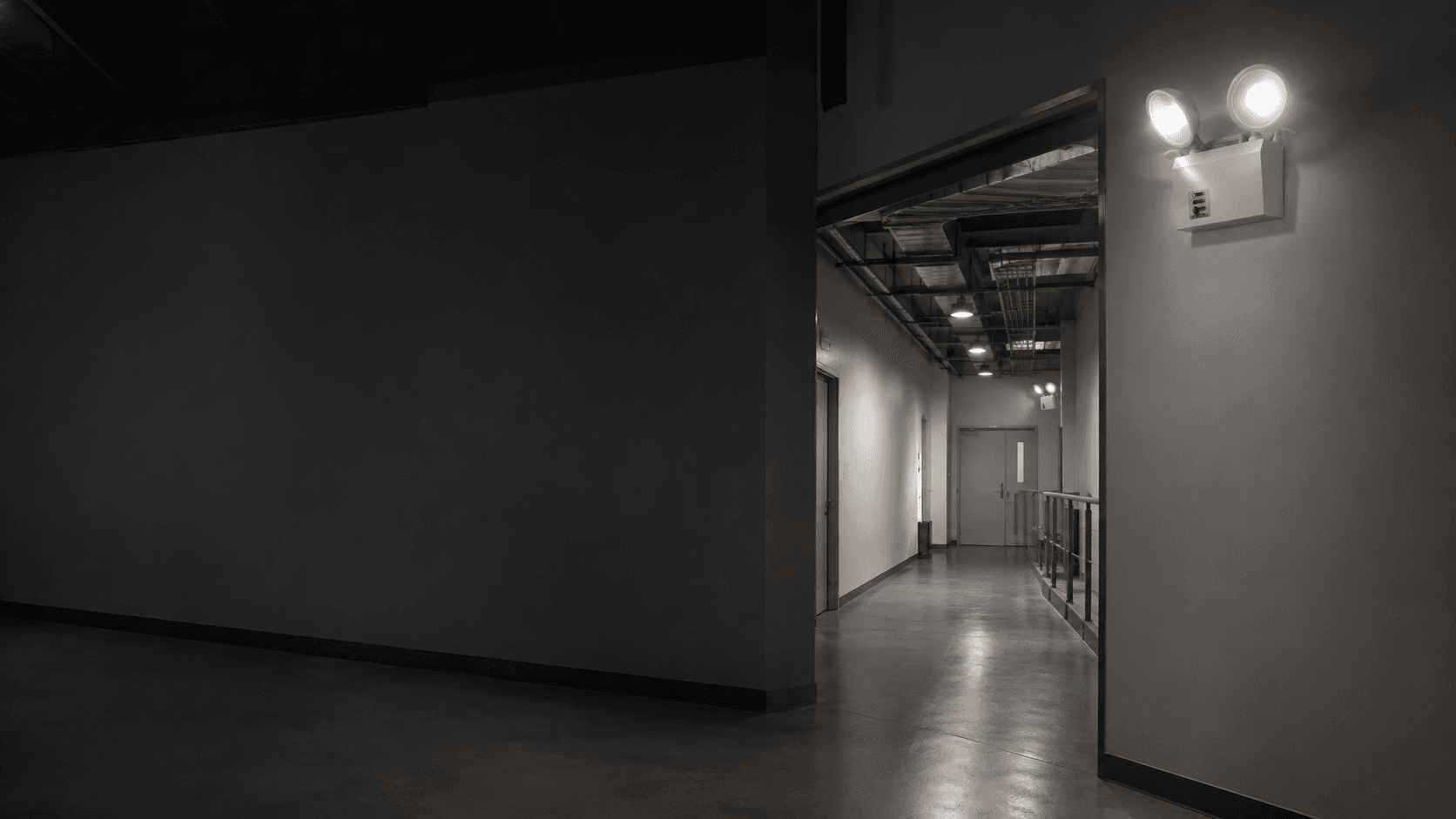 Professional building corridor with illuminated emergency exit guidance and emergency lighting