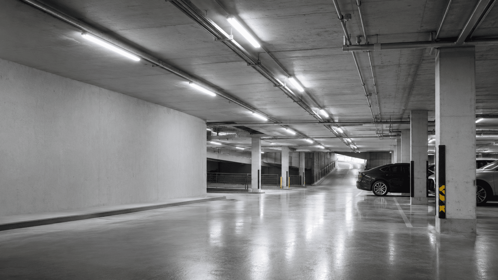 Underground car park interior lit by linear LED luminaires along the ceiling